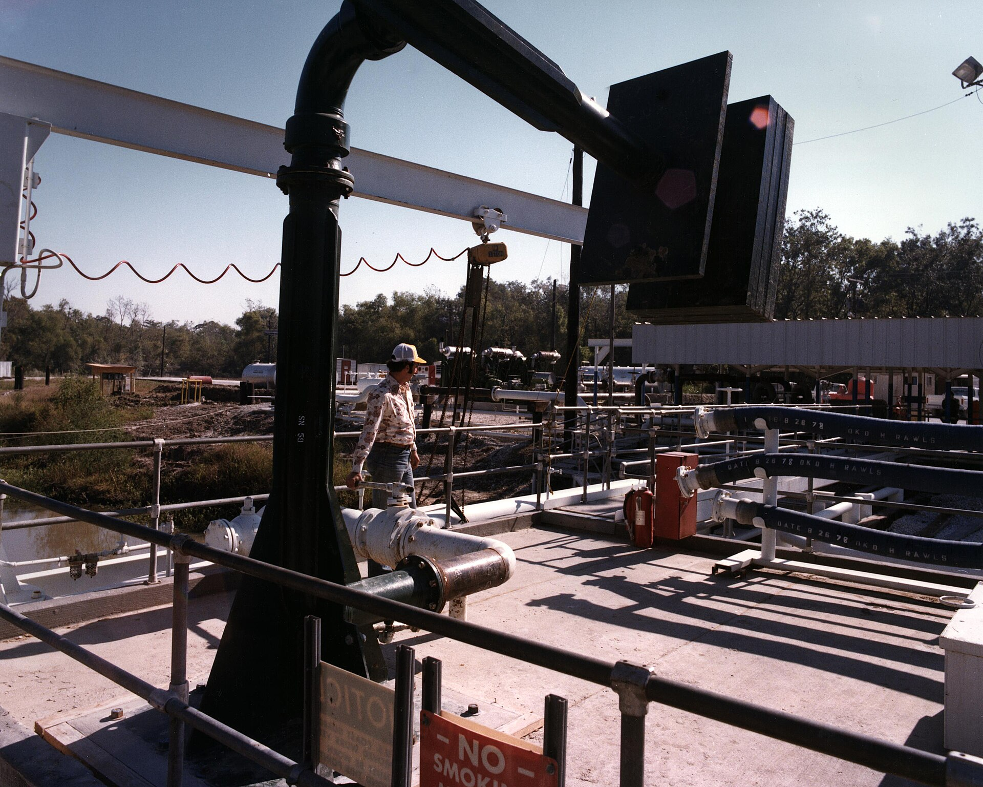 A worker controls the flow of crude oil through a loading arm at the Bull Bay Terminal, part of the United States Strategic Petroleum Reserve.