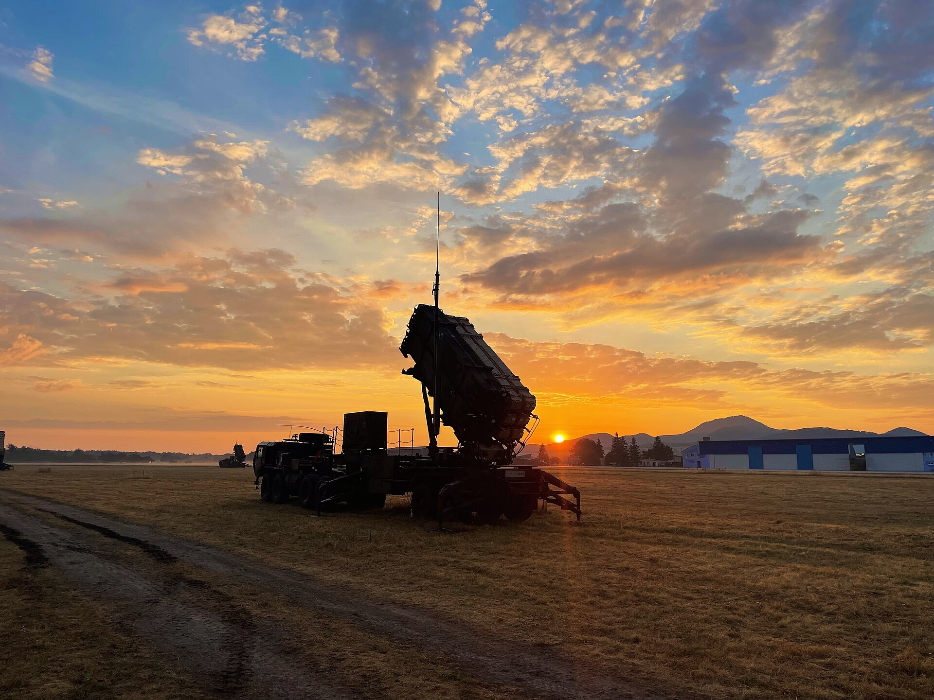 A Patriot missile launcher in Slovakia, with the sun rising behind it.